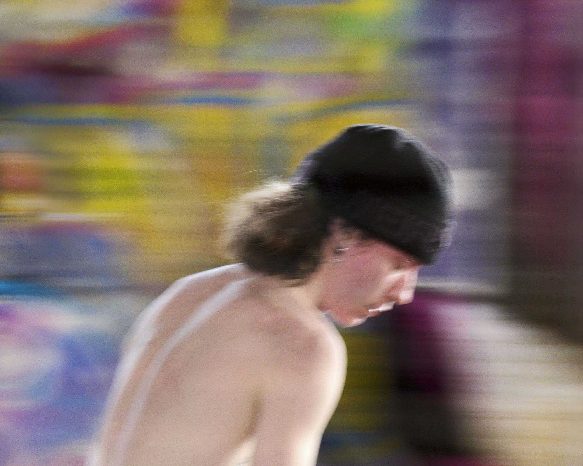 http://Artistic%20motion%20blur%20image%20capturing%20the%20dynamic%20movement%20of%20a%20shirtless%20skater%20wearing%20a%20black%20beanie,%20seen%20from%20the%20side%20with%20a%20vibrant,%20abstract%20background.